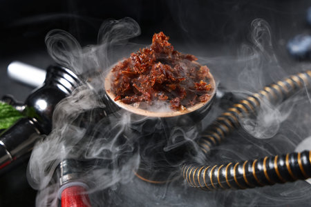 Parts of hookah with tobacco on black background