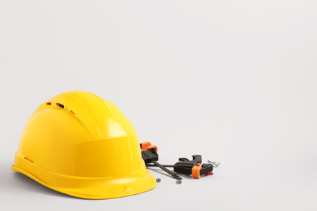 Yellow hardhat with clamps, screws and bolts on white backgroundの写真素材