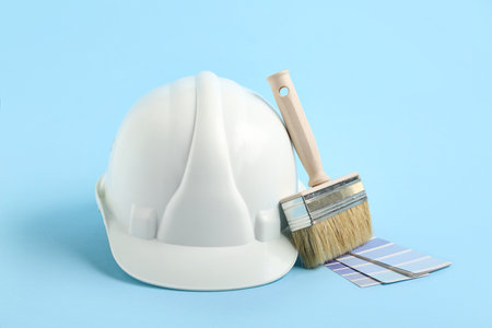 White hardhat with brush and color palettes on blue backgroundの写真素材