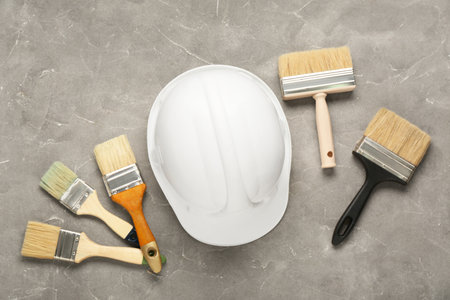 White hardhat with brushes on gray grunge backgroundの写真素材