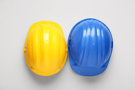 Blue and yellow hardhats on white backgroundの写真素材