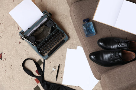 Vintage typewriter with accessories on carpet in room, top view