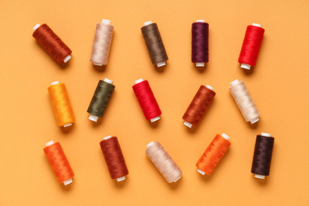 Many different thread spools on orange background