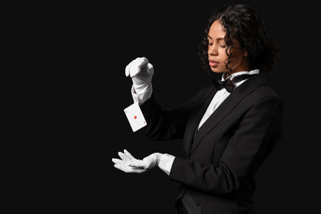 Young African-American magician with flying card on black backgroundの写真素材