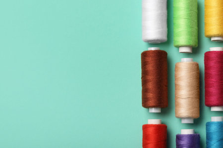 Set of different thread spools on mint background, closeup