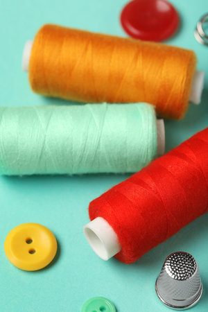 Composition with thread spools on mint background, closeup