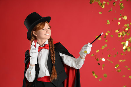 Young magician showing magic trick with stars on red backgroundの写真素材