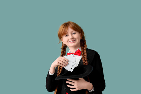 Young magician showing magic trick with playing cards on green backgroundの写真素材