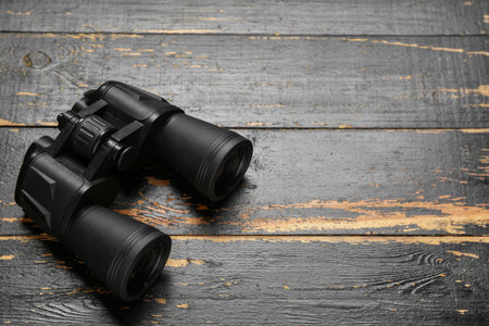 Modern binoculars on black wooden backgroundの写真素材
