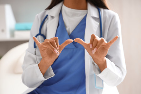 Female doctor using sign language in clinic, closeupの写真素材