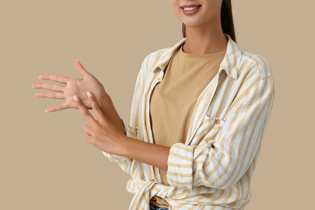 Young woman using sign language on beige backgroundの写真素材