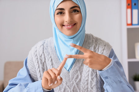Young Muslim deaf mute businesswoman using sign language in office, closeupの写真素材