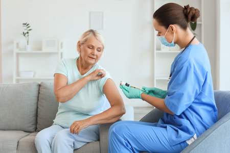 Senior woman receiving vaccine from doctor at homeの写真素材