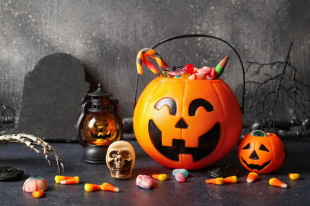 Baskets with tasty treats and decorations for Halloween on dark backgroundの写真素材