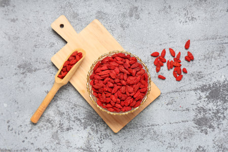 Bowl and scoop with dried goji berries on gray grunge backgroundの写真素材
