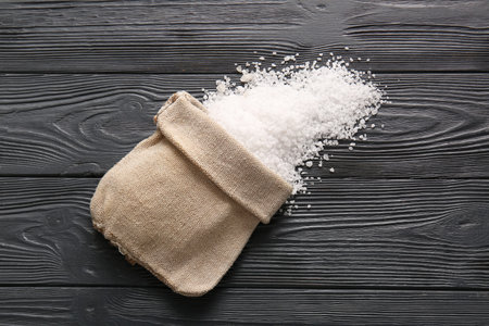 Sack bag with sea salt on dark wooden backgroundの写真素材