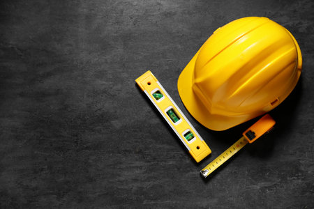 Hardhat and construction tools on black grunge background, top viewの写真素材