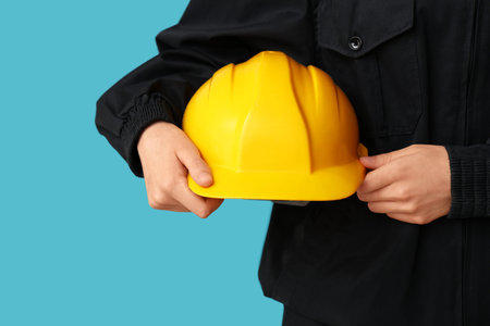 Worker with hardhat on blue background, closeup