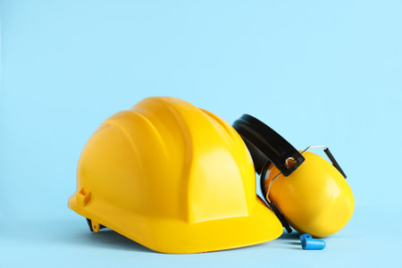Hardhat and protective earmuffs on blue backgroundの写真素材