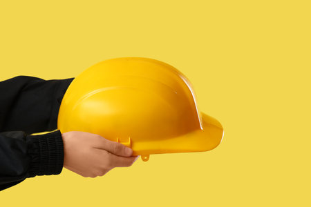 Worker with hardhat on yellow backgroundの写真素材
