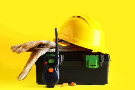 Hardhat, tool box and radio transceiver on yellow backgroundの写真素材