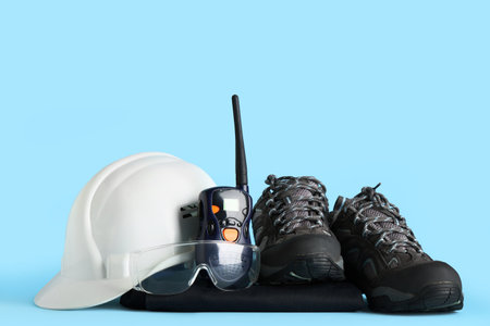 Hardhat, boots, safety glasses and radio transceiver on blue backgroundの写真素材