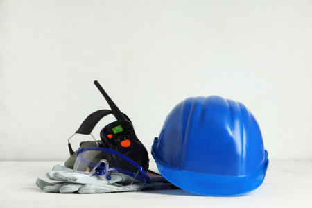 Hardhat, gloves and radio transceiver on white grunge backgroundの写真素材