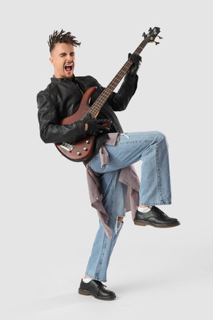 Cool young man with dreadlocks playing guitar on white backgroundの写真素材