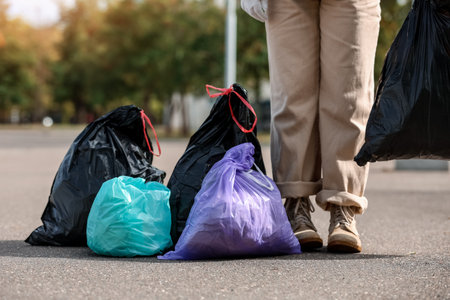 Woman with garbage bags on streetの写真素材