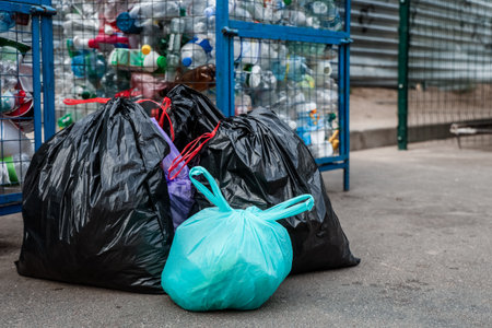 Garbage bags near recycling cage with plastic bottles outdoorsの写真素材