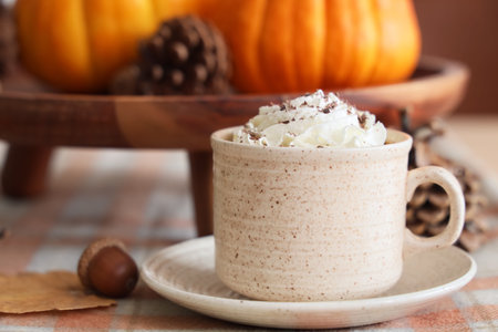 Cup of pumpkin latte on table in room, closeupの写真素材