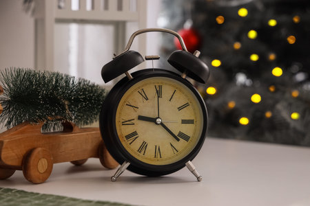 Alarm clock with Christmas tree and toy car on table in kitchen, closeupの写真素材