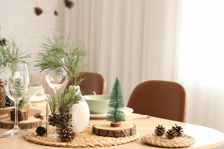 Winter table setting with pine cones and branches in roomの写真素材