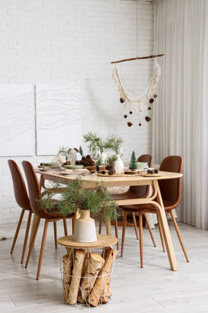 Interior of room with dining table, fir branches and paintingsの写真素材