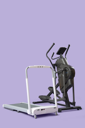 Modern elliptical machine with treadmill on lilac background