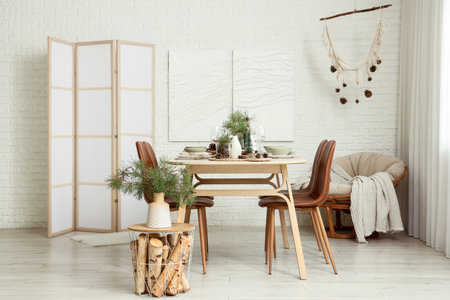 Interior of room with dining table, pine branches and armchairの写真素材
