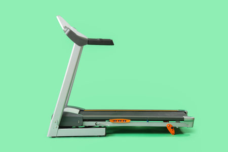 Modern treadmill on green backgroundの写真素材