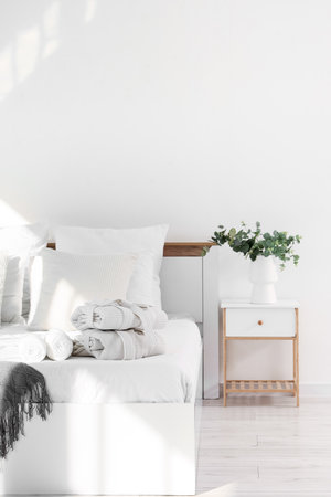 Interior of hotel room with bed, folded bathrobes and tableの写真素材
