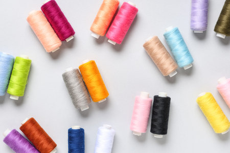 Colorful thread spools on gray background