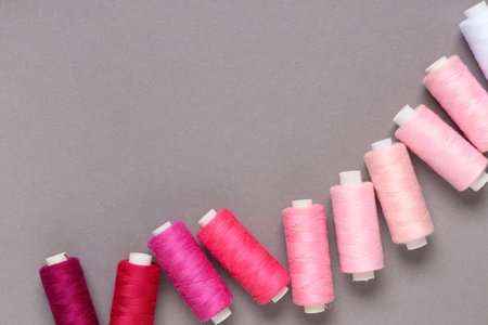 Different pink thread spools on gray backgroundの写真素材