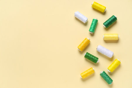 Colorful thread spools on beige backgroundの写真素材