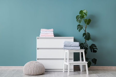 Interior of room with commode, stool and bed sheetsの写真素材