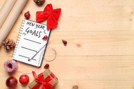 Notebook with New Year goals and Christmas decor on wooden backgroundの写真素材