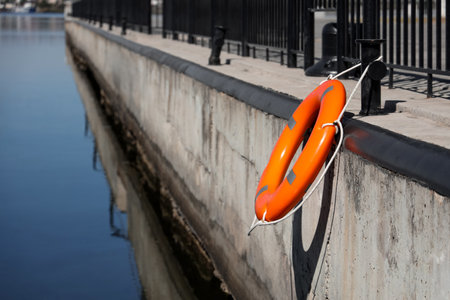 Bollard with lifebuoy ring on embankmentの写真素材