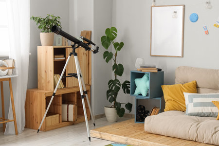 Interior of children's room with telescope, sofa and shelvesの写真素材