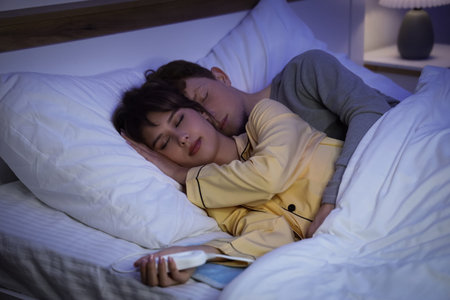 Young couple sleeping on electric heating pad in bedroom at night