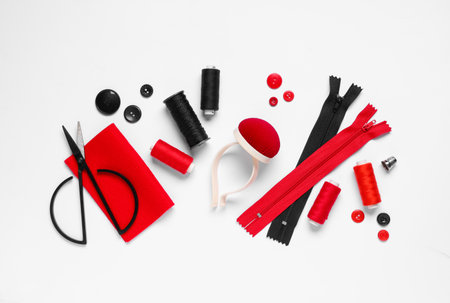 Thread spools with scissors, buttons, zippers, pin cushion and fabric on white backgroundの写真素材