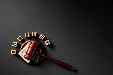 Word ROBBERY and judge's gavel with money on dark backgroundの写真素材