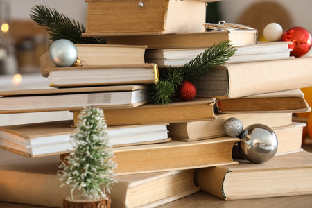 Books with Christmas balls and fir branches on table in kitchen, closeupの写真素材