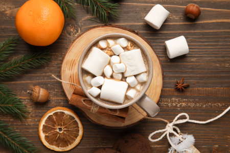 Cup of cocoa with treats and fir branches on wooden background. Hello winterの写真素材